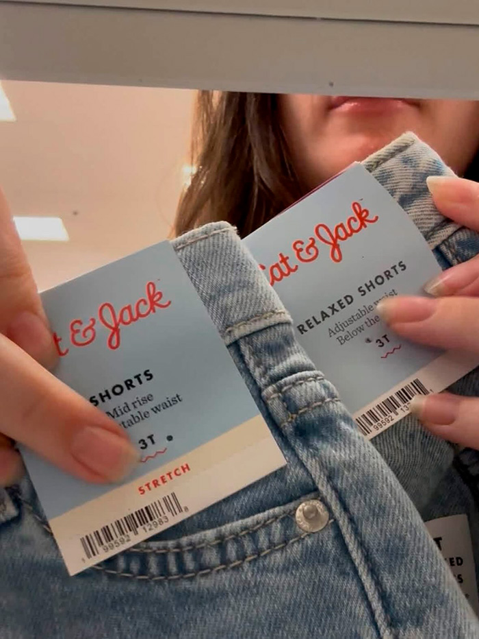 Close-up of a shopper holding two pairs of back-to-school denim kids clothing shorts with tags showing size 3T. Close-up of a shopper holding two pairs of back-to-school denim kids clothing shorts with tags showing size 3T.
