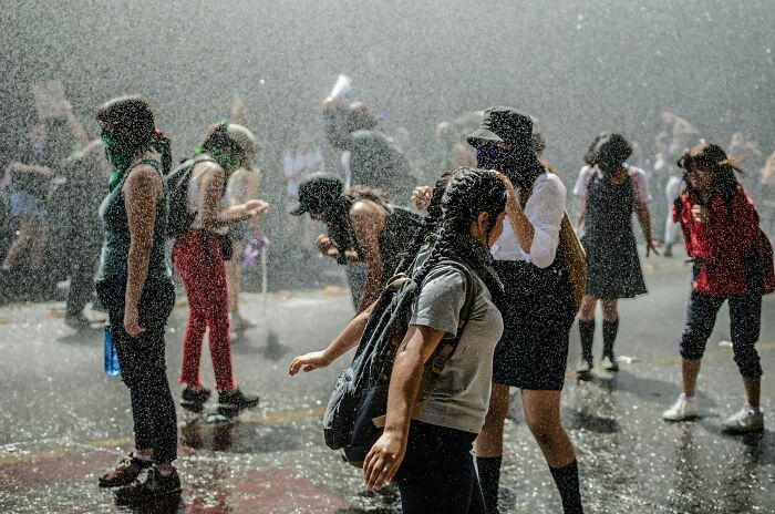 Students in rain at an outdoor event, a new world experience of college life and freedom.