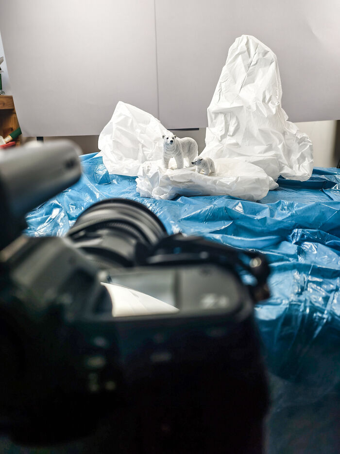 Behind-the-scenes of a miniature habitat: camera set up to photograph polar bears on plastic, showing waste and endangered animals. Behind-the-scenes of a miniature habitat: camera set up to photograph polar bears on plastic, showing waste and endangered animals.