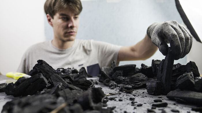 Photographer creating miniature habitats, arranging waste materials to show how waste is endangering animals. Photographer creating miniature habitats, arranging waste materials to show how waste is endangering animals.
