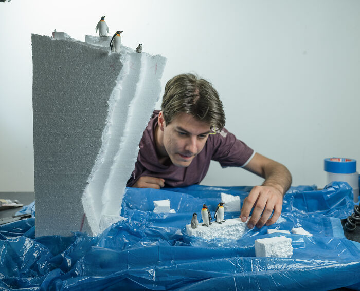 A photographer creating miniature habitats with penguins on foam, illustrating how waste and industry are endangering animals. A photographer creating miniature habitats with penguins on foam, illustrating how waste and industry are endangering animals.