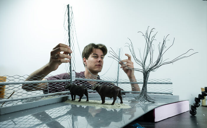 A photographer builds miniature habitats with animal figures, highlighting how waste and industry endanger animals. A photographer builds miniature habitats with animal figures, highlighting how waste and industry endanger animals.