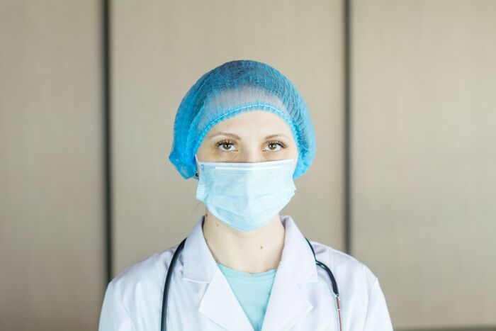 Female medical professional wearing a mask and cap, symbolizing the career path freedom college life can bring.
