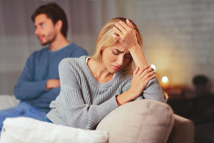 A heartbroken bestie looks sad as her ex-boyfriend sits in the background. A heartbroken bestie looks sad as her ex-boyfriend sits in the background.