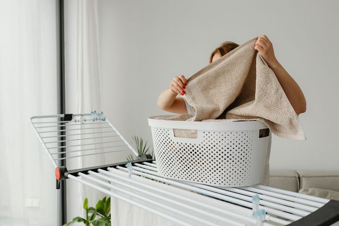 A woman hangs laundry, enjoying her privacy and living alone as a single person.
