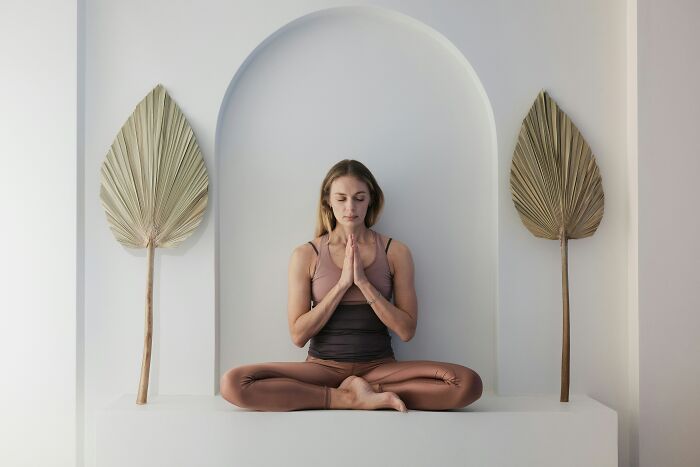 A woman meditating in a serene setting, showcasing the self-care and enjoyment of living alone and being single.