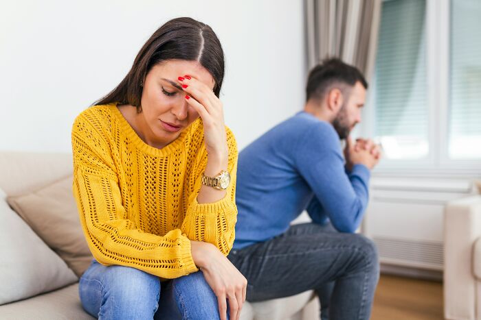 A woman looking upset with her hand on her forehead, and a man looking away, representing feelings of being single.