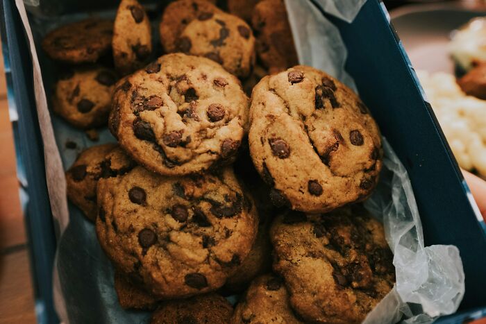A close-up of delicious chocolate chip cookies in a box, a comforting aspect of living alone and being single.