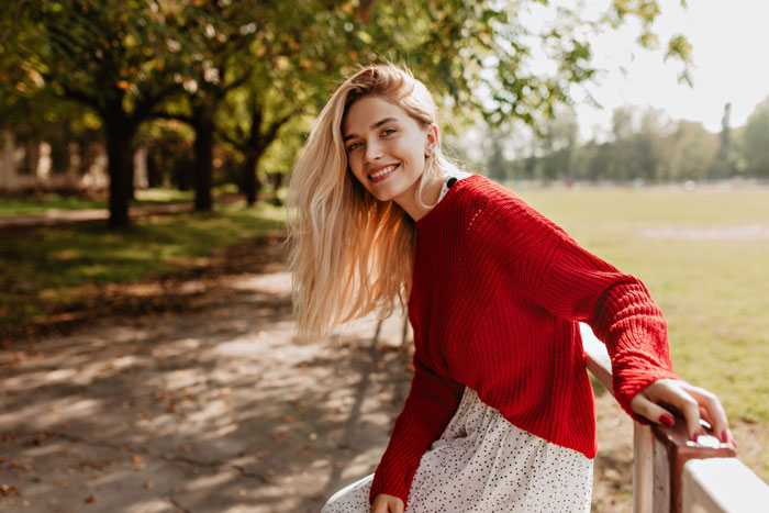 Woman smiling in a park, representing the ex-girlfriend sending receipts about a man playing his friends. Woman smiling in a park, representing the ex-girlfriend sending receipts about a man playing his friends.