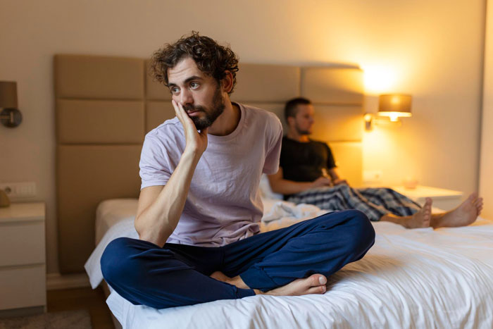 A man sits on a bed, looking troubled, after his relationship unravels and his BF's dark secrets spill out. A man sits on a bed, looking troubled, after his relationship unravels and his BF's dark secrets spill out.