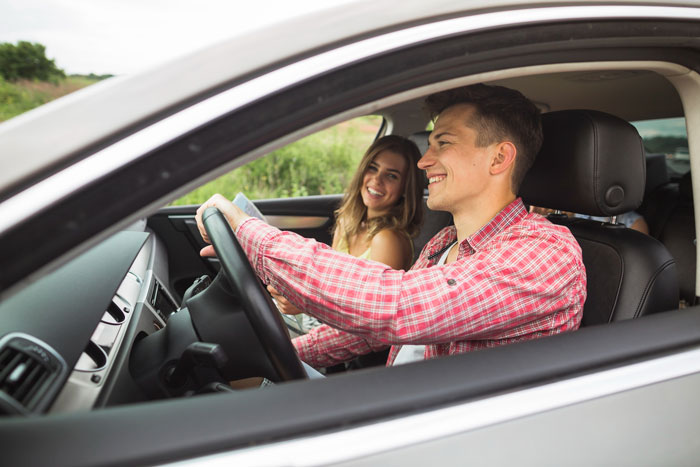 A happy couple in a car, illustrating a relationship before secrets spill out. A happy couple in a car, illustrating a relationship before secrets spill out.