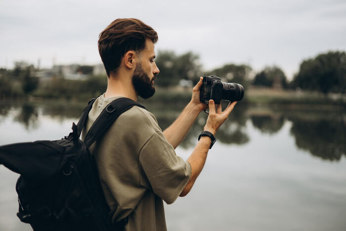A photographer by a river, capturing a trash-the-dress shoot, unaware of the tragic drowning. A photographer by a river, capturing a trash-the-dress shoot, unaware of the tragic drowning.