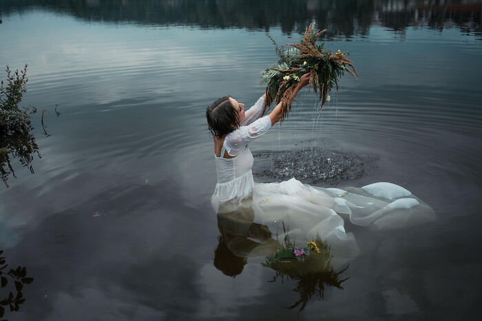 A bride immersed in a river, holding a bouquet, during a trash-the-dress photoshoot, moments before drowning. A bride immersed in a river, holding a bouquet, during a trash-the-dress photoshoot, moments before drowning.