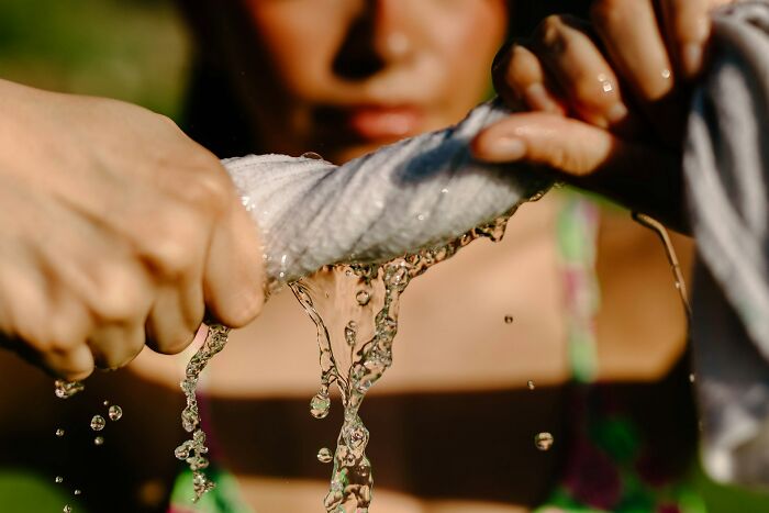 Hands wringing out a wet cloth, illustrating the surprising nature of scientific facts.