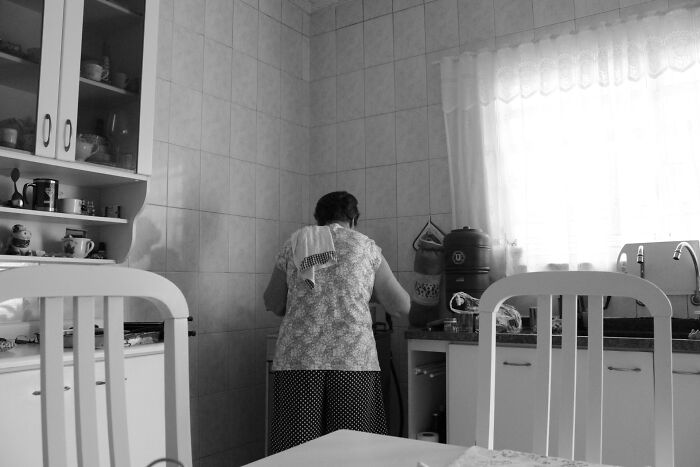 A black and white image of a woman in a kitchen, perhaps thinking about scary true stories.