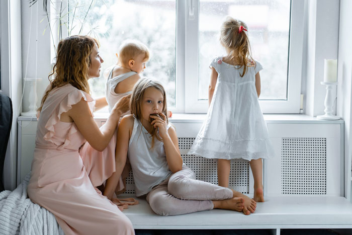 A woman and three children sitting by a window, with the woman looking at one child while another child eats. The woman is happy toxic sis is infertile. A woman and three children sitting by a window, with the woman looking at one child while another child eats. The woman is happy toxic sis is infertile.