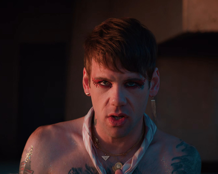 Rock star unrecognizable, with glitter makeup and jewelry, revealing his coming out as gay.