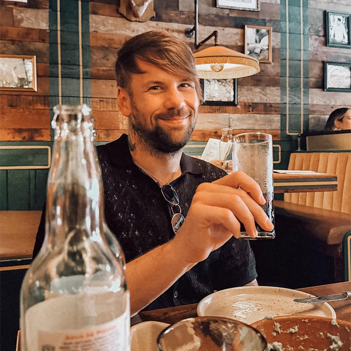 Rock star smiling at a restaurant, unrecognizable after coming out as gay despite 14-year marriage.