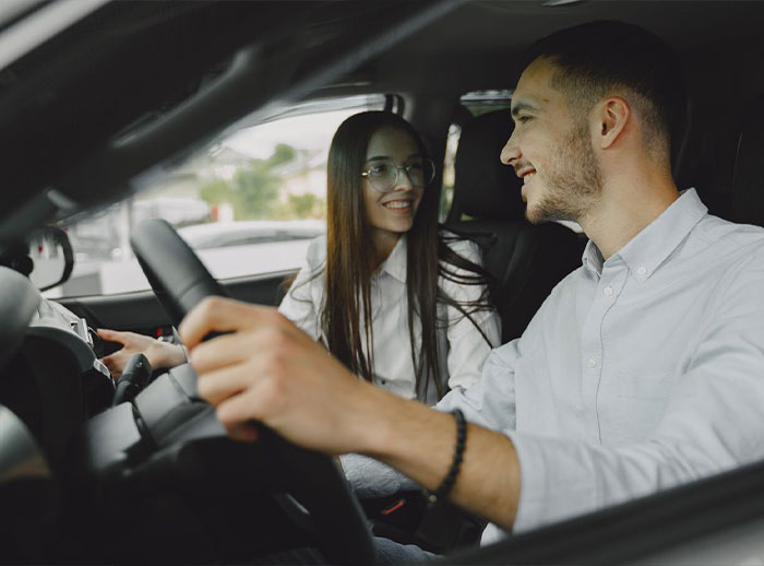 A happy Christian woman in glasses smiles at her partner while they are in a car, discussing marriage advice. A happy Christian woman in glasses smiles at her partner while they are in a car, discussing marriage advice.