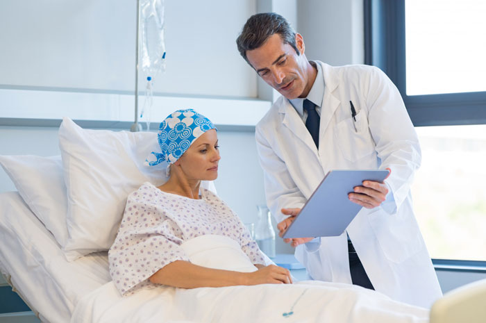 A doctor showing a tablet to a patient with a headscarf in a hospital, discussing her goodbye video. A doctor showing a tablet to a patient with a headscarf in a hospital, discussing her goodbye video.