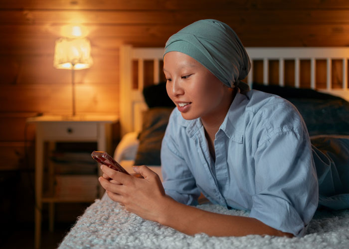 A young woman with a headscarf smiling while looking at her phone, possibly viewing or planning her goodbye video. A young woman with a headscarf smiling while looking at her phone, possibly viewing or planning her goodbye video.