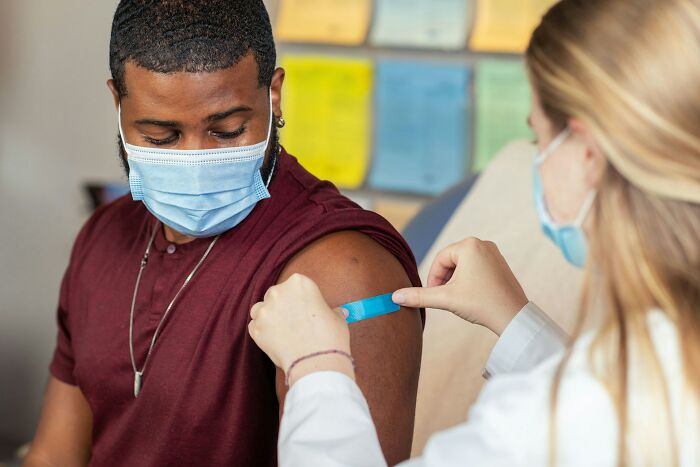 A medical field worker applies a bandage to a patient's arm. This highlights the care medical field workers provide.
