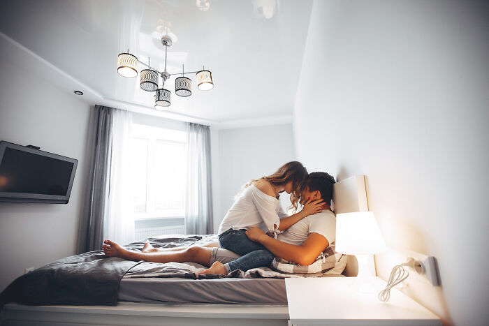 A couple sharing an intimate moment in bed, reflecting reasons for becoming affair partners.