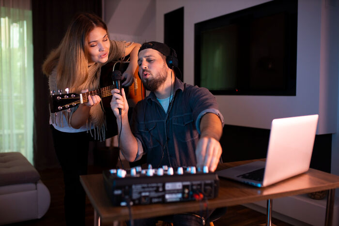 A man and a woman sing together in a recording studio, highlighting the reasons people became affair partners.