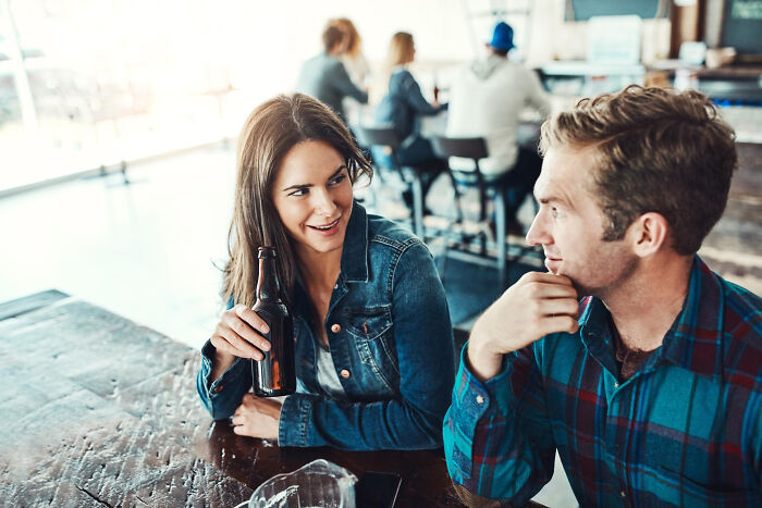 A couple at a bar, talking intensely, perhaps about their experiences as affair partners.