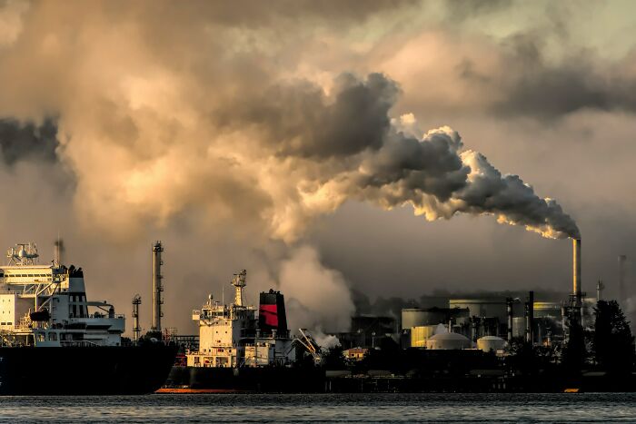 Industrial complex emitting thick smoke into the sky, highlighting scary science facts about pollution.