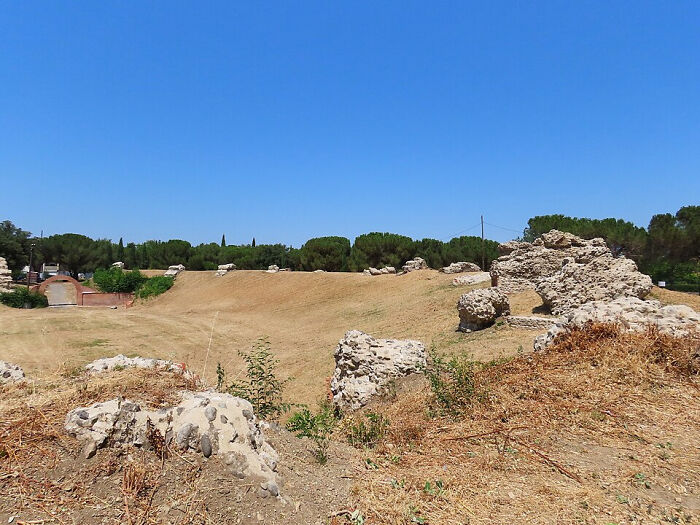 Arid, yellow grass and ancient ruins under a clear sky, illustrating Europe's brutal drought.