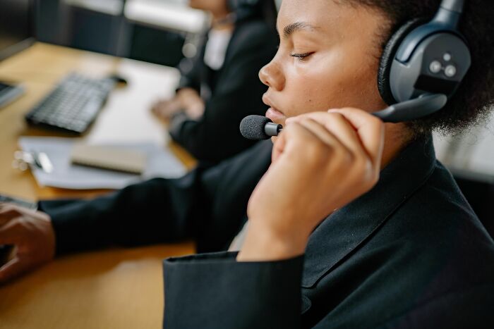A call center agent with a headset, focused on her work, offering insider knowledge on customer service industries.