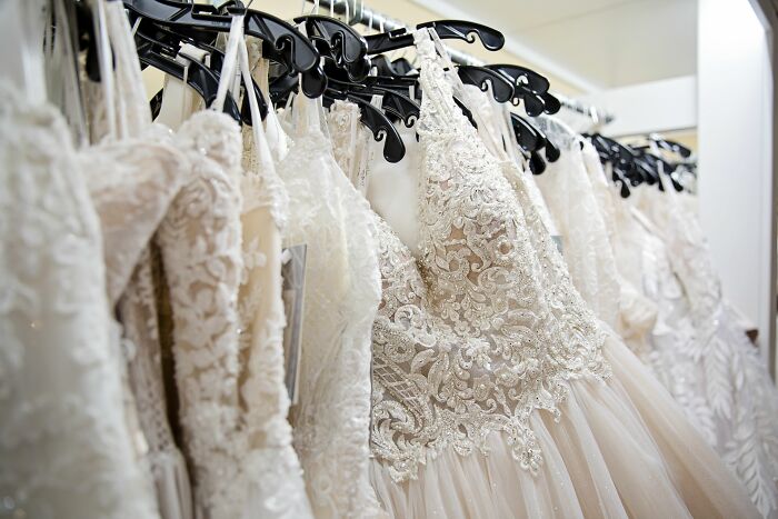 A rack of elegant wedding dresses with intricate lace and beadwork. Uncover insider knowledge from different industries.