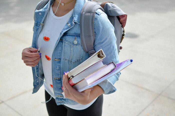 A student with a backpack and books, representing insider knowledge in education and learning.