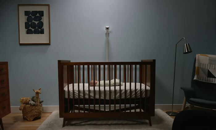 A baby sleeps in a crib with a monitor, representing the careful decisions companies make.