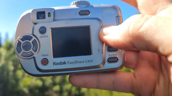 A hand holding a Kodak EasyShare C310 digital camera, an example of companies that used to dominate the market.