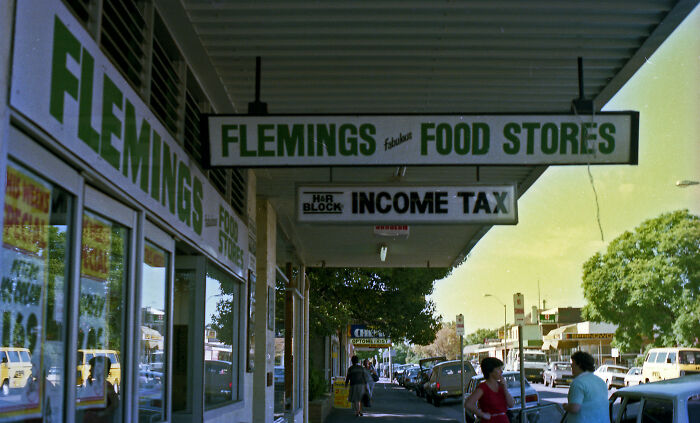 An exterior shot of Flemings Food Stores and an Income Tax office, showing companies and their market presence.
