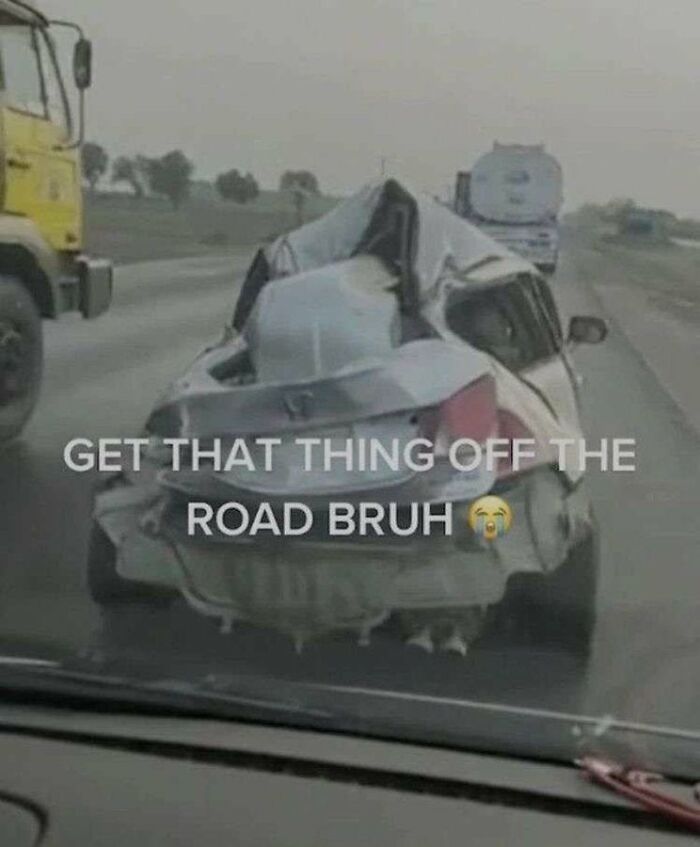 A severely crashed car on the road, highlighting a dumb situation. 