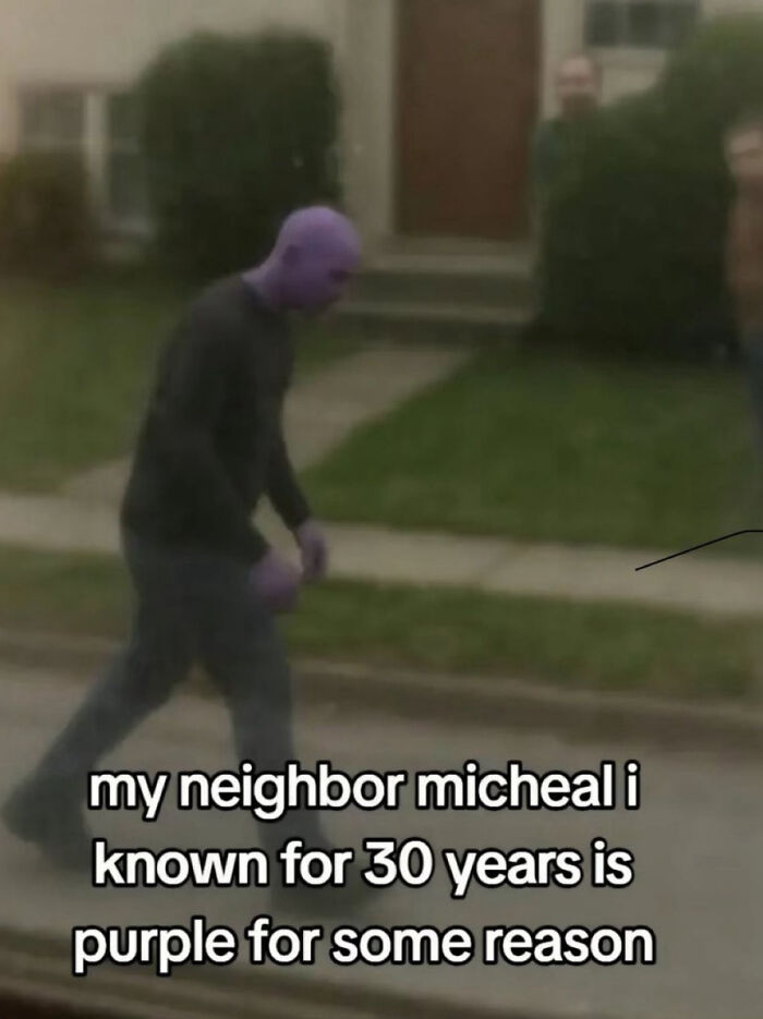 A man walking on a sidewalk, appearing purple, an example of a dumb internet moment. 
