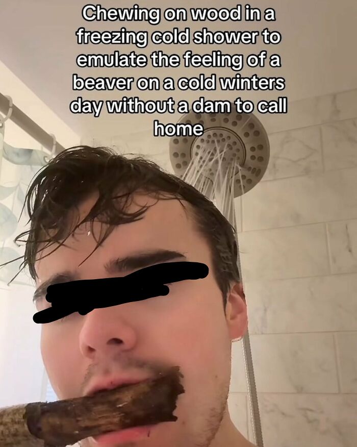 A man in a shower chewing on a piece of wood, a prime example of dumb internet content and low IQ.