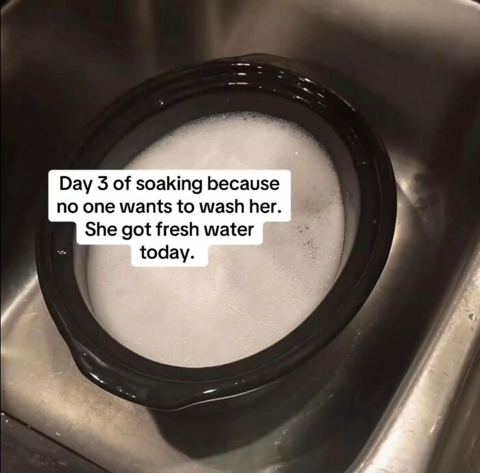 A black bowl with soapy water in a sink, highlighting a dumb situation or object that needs cleaning.