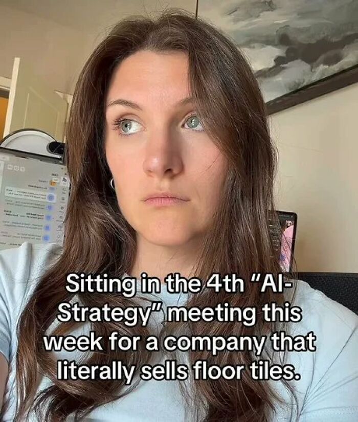 Woman looking bored in a corporate meeting, representing corporate absurdity.