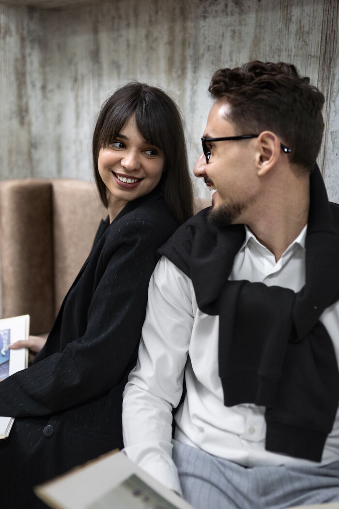 Two coworkers smiling and laughing, sharing personal details.
