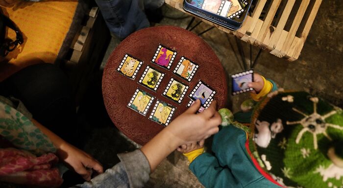 A high-angle shot of people playing a visual quiz game with cards, recognizing advanced English words. A high-angle shot of people playing a visual quiz game with cards, recognizing advanced English words.