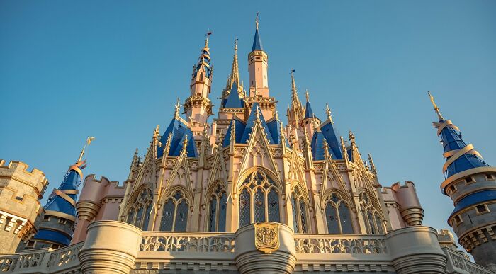 A majestic Disney castle against a clear blue sky, featuring multiple spires and intricate architectural details, perfect for a Disney songs quiz. A majestic Disney castle against a clear blue sky, featuring multiple spires and intricate architectural details, perfect for a Disney songs quiz.