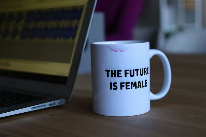 A mug with The Future is Female and a laptop, related to employee stories for HR pros about getting fired.