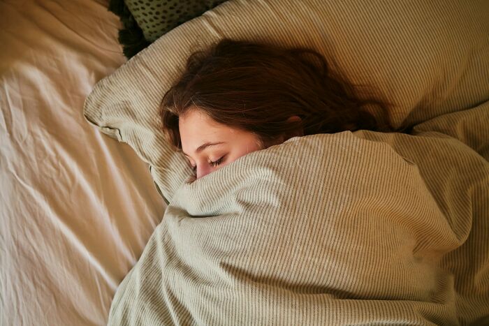 A person sleeping soundly under a blanket, contrasting with times teachers were terrified of their own students.