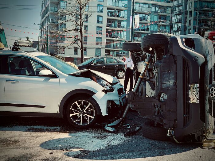 A car accident with one vehicle overturned and another with front-end damage, highlighting dangerous situations teachers may encounter.