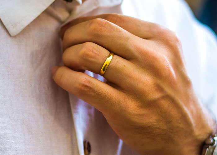 A man's hand wearing a gold wedding ring, symbolizing how women caught their soulmates cheating.