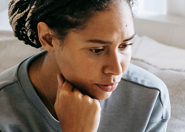 A woman looking down, lost in thought, possibly contemplating if her soulmate is cheating.